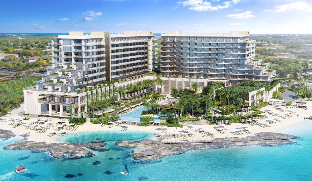 Grand Hyatt Grand Cayman Residences from above, before the shining blue ocean and lined with white beachfront and palm trees